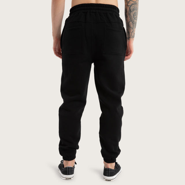 Model wears Unthought Heavy Trackpant Jet Black Trackpants in Black - Image 7