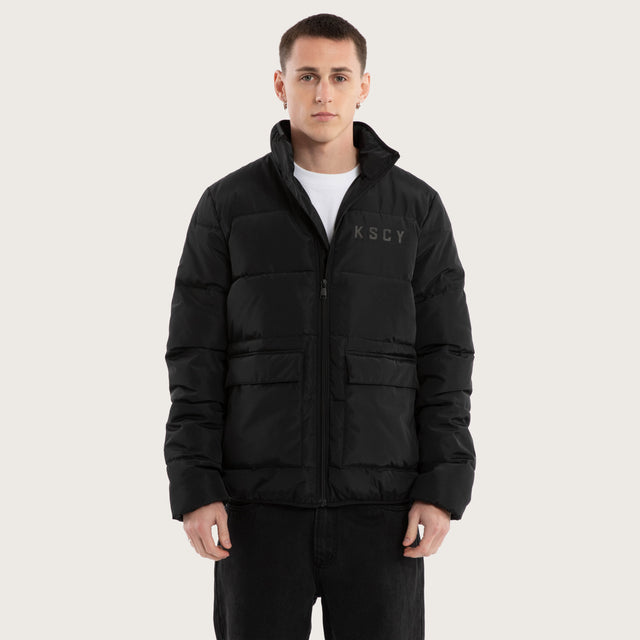 Model wears Solitary Puffer Jacket Jet Black Jackets in Black - Image 1