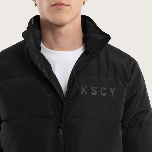 Model wears Solitary Puffer Jacket Jet Black Jackets in Black - Image 5