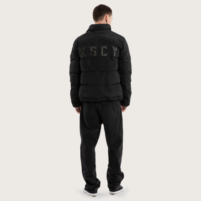 Model wears Solitary Puffer Jacket Jet Black Jackets in Black - Image 2