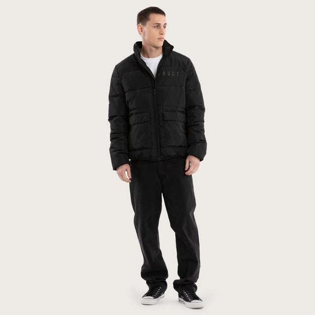 Model wears Solitary Puffer Jacket Jet Black Jackets in Black - Image 4