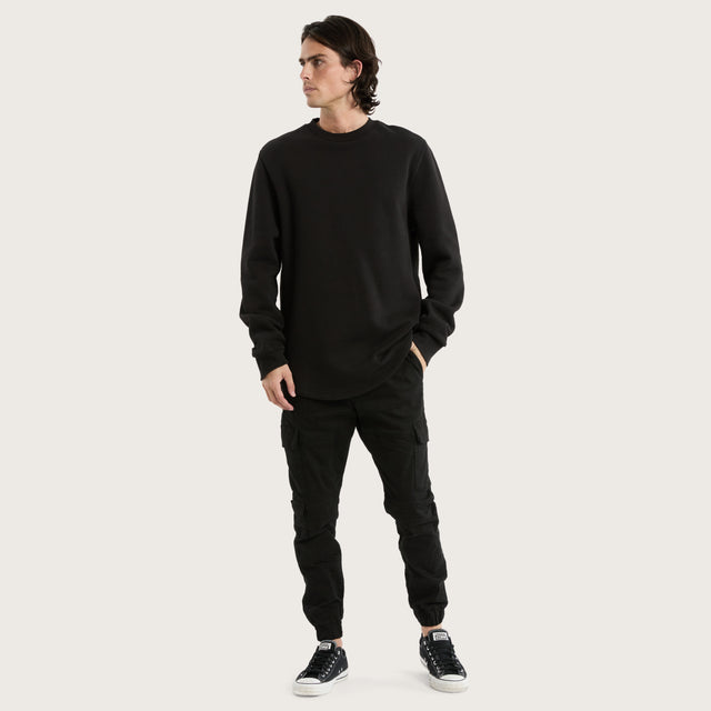 Model wears Miles Dual Curved Sweater Jet Black Jumpers in Black - Image 2