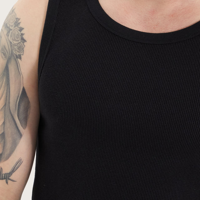 Model wears Weiza Singlet Jet Black Tanks in Black - Image 2