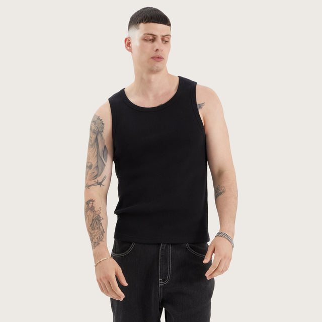 Model wears Weiza Singlet Jet Black Tanks in Black - Image 1