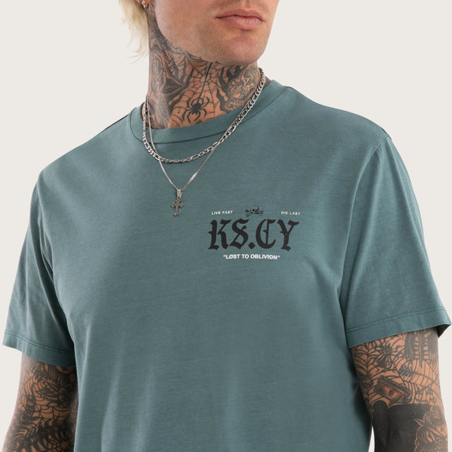 Model wears England Curved Hem Tee in Green T-Shirts in Green - Image 6