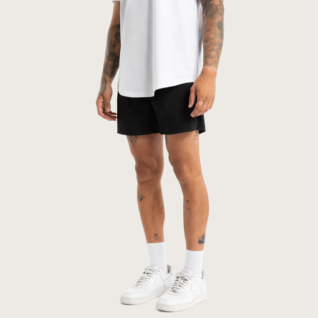 Model wears Endurance Sport Short Jet Black Shorts in Black - Image 1