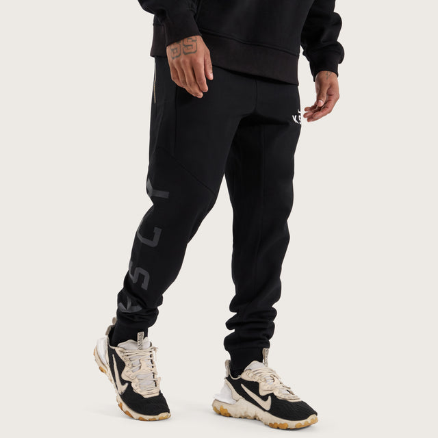 Model wears Flex Track Pant Jet Black Pants in Black - Image 7