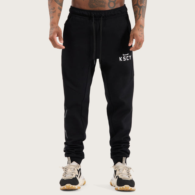 Model wears Flex Track Pant Jet Black Pants in Black - Image 2