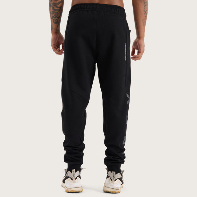Model wears Flex Track Pant Jet Black Pants in Black - Image 9