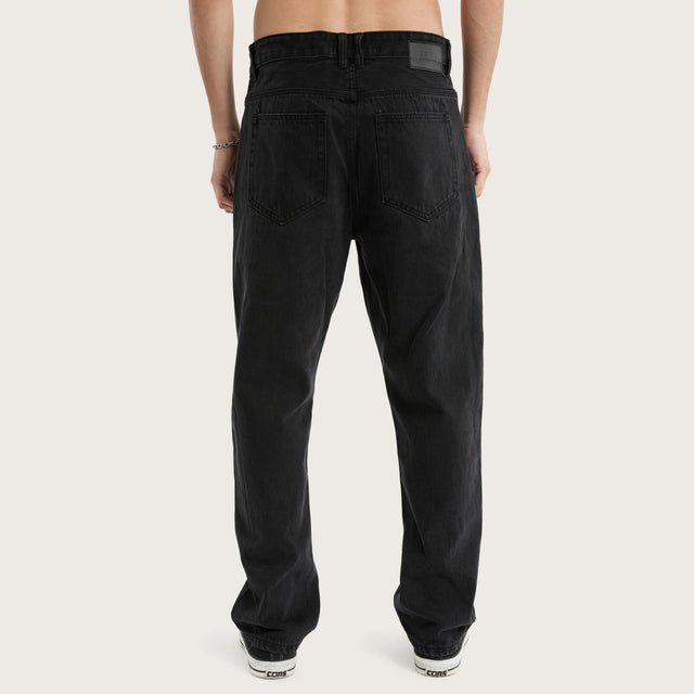 Model wears K5 Relaxed Fit Jean Black Grey Pants in Black - Image 4