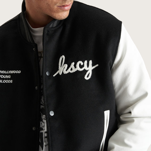 Model wears Code Vein Varsity Jacket Jet Black Jackets in Black - Image 7