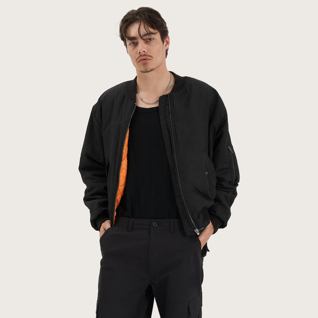 Model wears Gridlock Bomber Jacket Jet Black Jackets in Black - Image 1