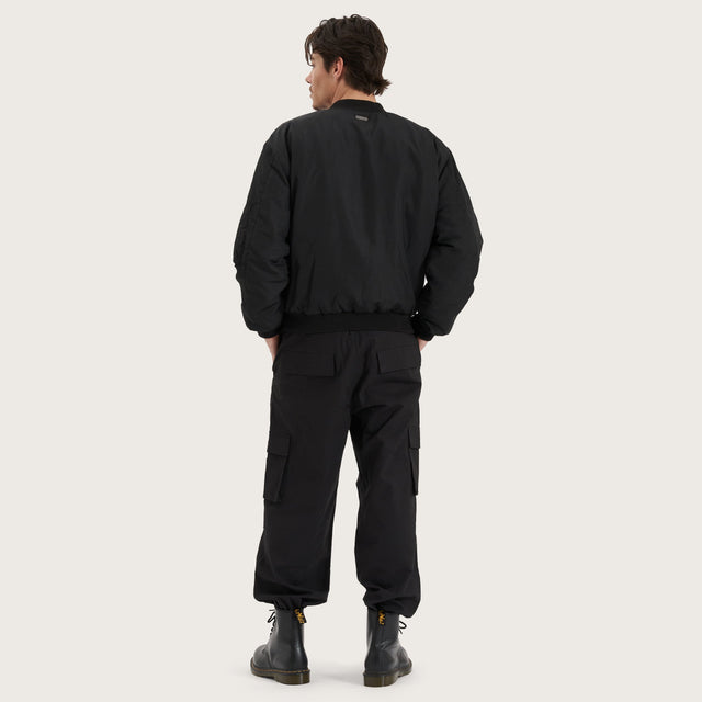 Model wears Gridlock Bomber Jacket Jet Black Jackets in Black - Image 11