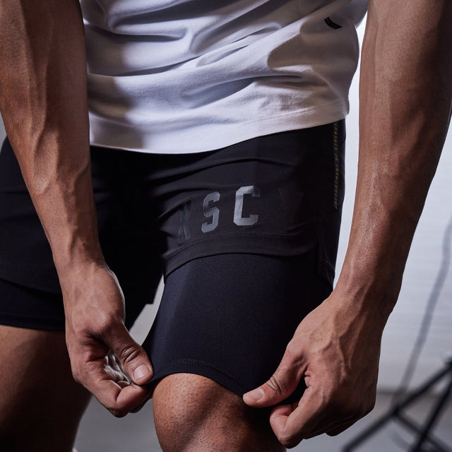 Model wears Hybrid Elasticated Short with Lining Black Shorts in Black - Image 4