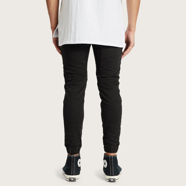 Model wears Hydra Denim Jogger Jet Black Pants in Black - Image 4