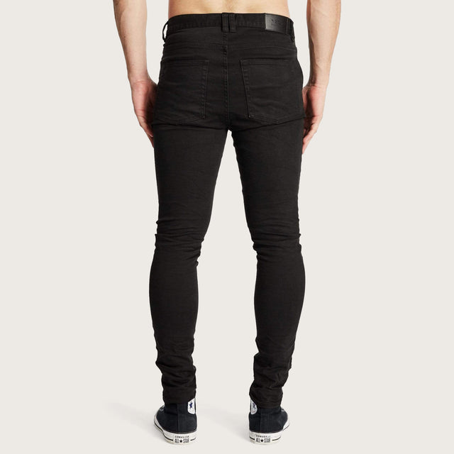 Model wears K1 MX Super Skinny Jeans Jet Black Pants in Black - Image 5