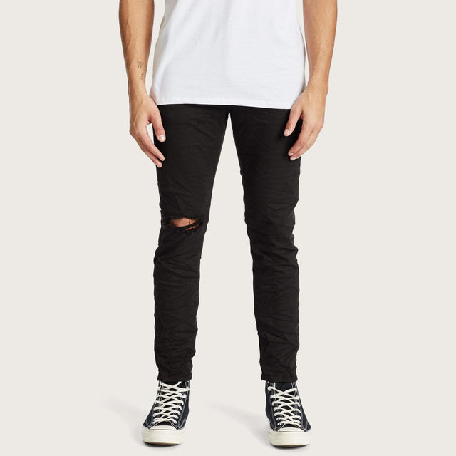 Model wears K2 Skinny Jean Destroyed Black Pants in Black - Image 1