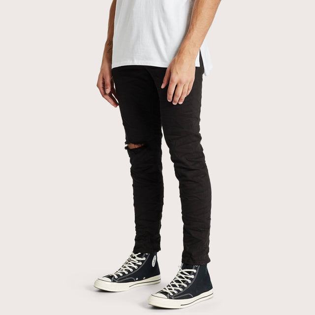 Model wears K2 Skinny Jeans Destroyed Black Pants in Black - Image 1