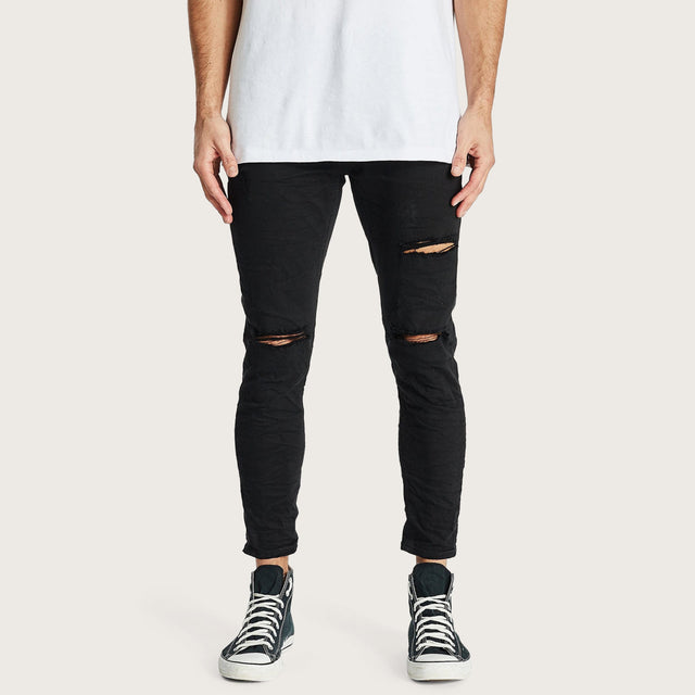 Model wears K4 Cropped Jean Destroyed Black Pants in Black - Image 1