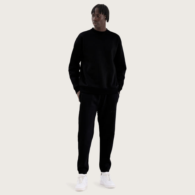 Model wears Kelsey Trackpant Jet Black Trackpants in Black - Image 2