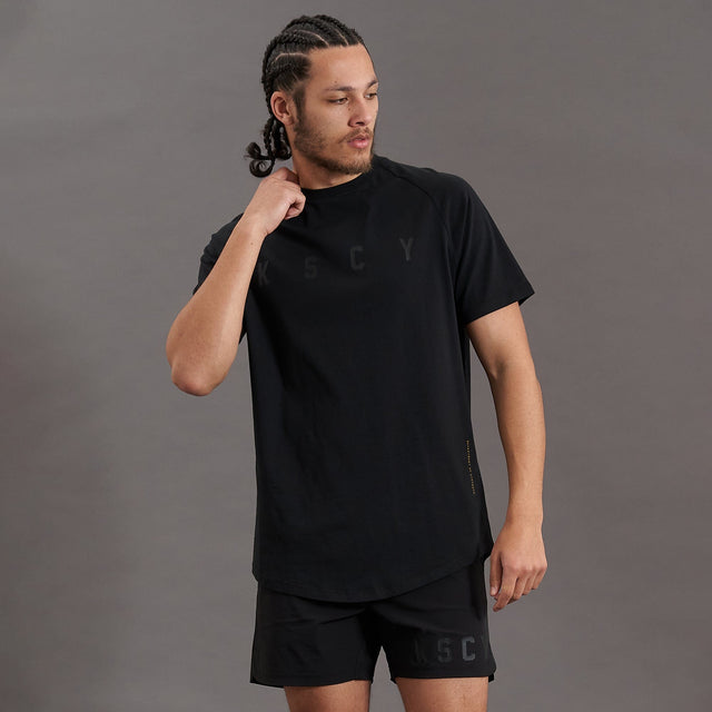 Model wears Process Raglan Curved Hem T-Shirt Jet Black T-Shirts in Black - Image 4
