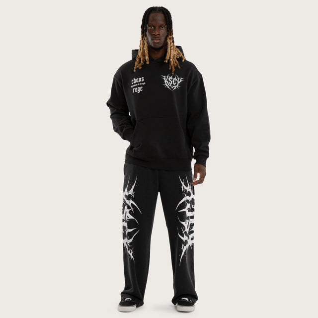 Model wears Chaotic Baggy Trackpant Black Trackpants Black – image 2