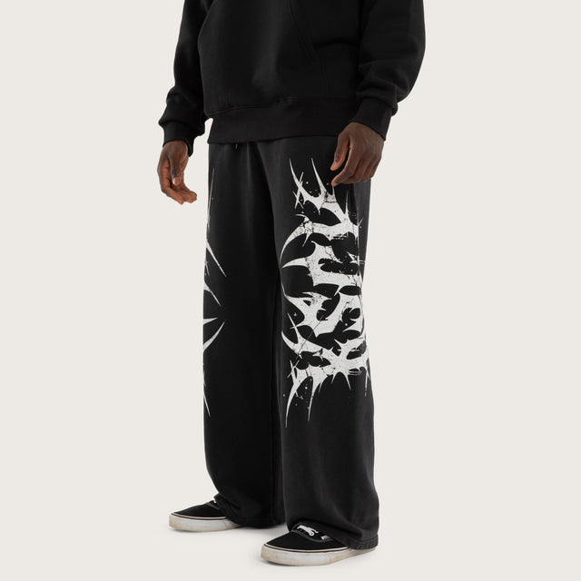 Model wears Chaotic Baggy Trackpant Black Trackpants Black – image 1