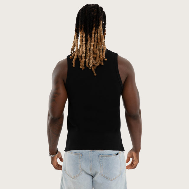 Model wears Weiza Waffle Cotton Singlet in Jet Black Tanks in Black - Image 3