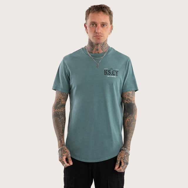 Model wears England Curved Hem Tee in Green T-Shirts in Green - Image 3