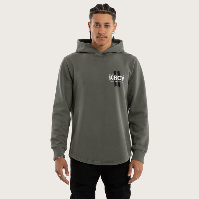 Model wears Inferno Curved Hem Hoodie in Green Hoodies in Green - Image 1