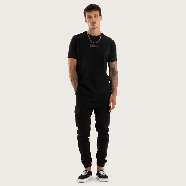 Model wears Recoil Curved Hem Tee Black T-Shirts in Black - Image 5