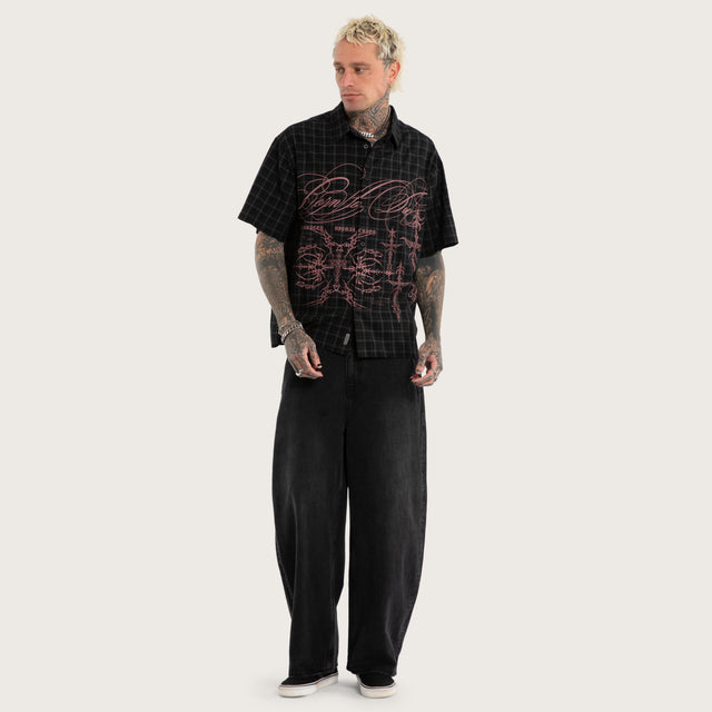 Model wears Luke Walker Phantom Button Up Short Sleeve Shirt Black Check Short Sleeve Shirts in Black - Image 5