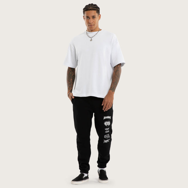 Model wears Sinner Trackpant Jet Black Trackpants in Black - Image 2