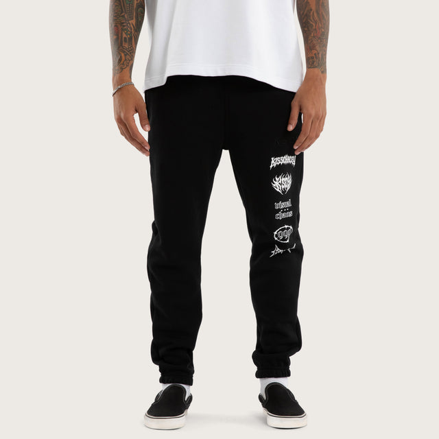 Model wears Sinner Trackpant Jet Black Trackpants in Black - Image 4