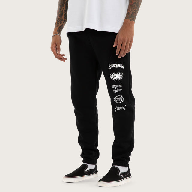 Model wears Sinner Trackpant Jet Black Trackpants in Black - Image 1
