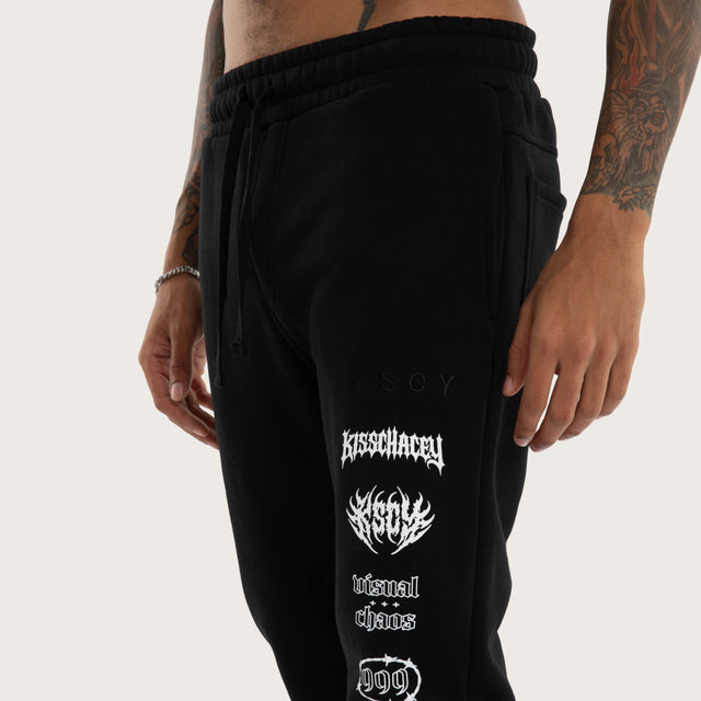 Model wears Sinner Trackpant Jet Black Trackpants in Black - Image 3
