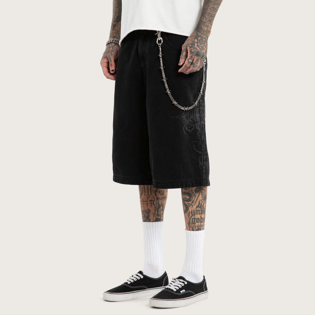 Model wears Luke Walker Tense K7 Super Baggy Jorts Black Shorts in Black - Image 1