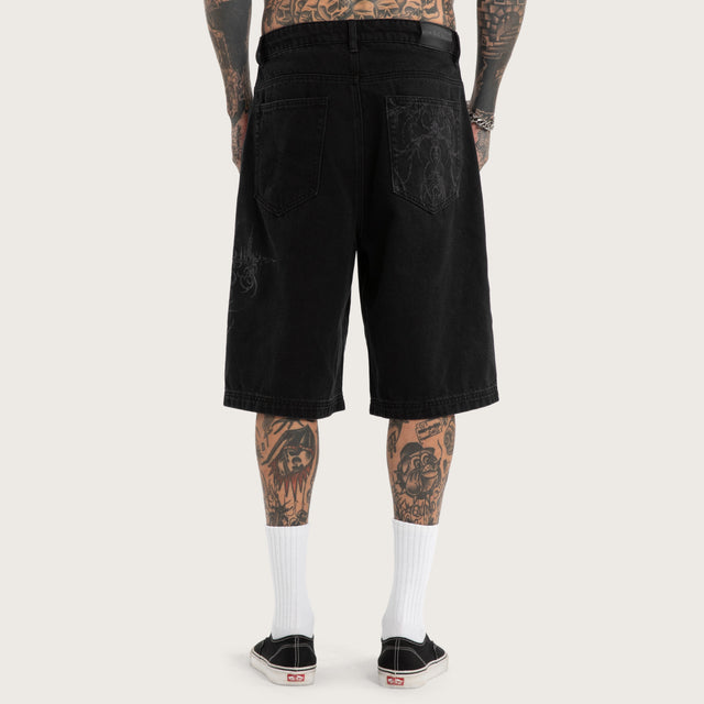 Model wears Luke Walker Tense K7 Super Baggy Jorts Black Shorts in Black - Image 3