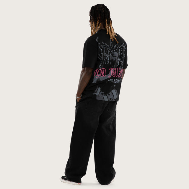Model wears CM Punk Pipe Bomb Street Tee Jet Black T-Shirts in Black - Image 7